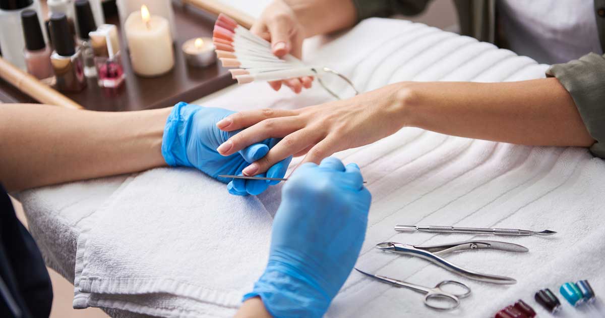 Foto van een schoonheidsbehandeling bij een nagelstyliste, een van de schoonheidsberoepen. Illustratie van ons artikel over RCoop, de coöperatie van de schoonheidsberoepen.